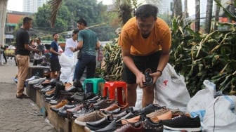 Pedagang menjajakan dagangannya pada lokasi bekas kebakaran di Pasar Taman Puring, Jakarta, Rabu (13/8/2025). [Suara.com/Alfian Winanto]