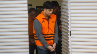 Staf Perizinan SB Grup, Aditya (tengah) mengenakan rompi tahanan usai terjaring Operasi Tangkap Tangan (OTT) di Gedung Merah Putih KPK, Jakarta, Kamis (14/8/2025). [Suara.com/Alfian Winanto]