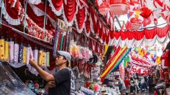 Warga mencari pernak-pernik kemerdekaan yang dijual di Pasar Jatinegara, Jakarta, Jumat (15/8/2025). [Suara.com/Alfian Winanto]