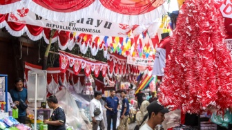 Warga mencari pernak-pernik kemerdekaan yang dijual di Pasar Jatinegara, Jakarta, Jumat (15/8/2025). [Suara.com/Alfian Winanto]