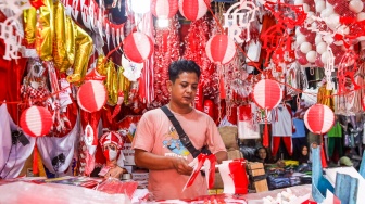 Warga mencari pernak-pernik kemerdekaan yang dijual di Pasar Jatinegara, Jakarta, Jumat (15/8/2025). [Suara.com/Alfian Winanto]