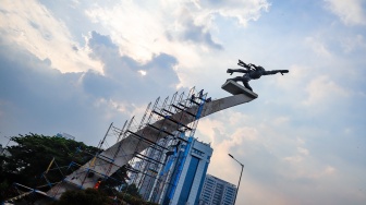 Pekerja melakukan perawatan patung Dirgantara atau patung Pancoran di Jakarta, Kamis (21/8/2025). [Suara.com/Alfian Winanto]