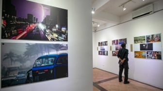 Pengunjung melihat foto yang dipamerkan pada pameran foto Rekam Jakarta 2025 di Cemara 6 Galeri, Jakarta, Sabtu (23/8/2025). [Suara.com/Alfian Winanto]