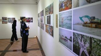 Pengunjung melihat foto yang dipamerkan pada pameran foto Rekam Jakarta 2025 di Cemara 6 Galeri, Jakarta, Sabtu (23/8/2025). [Suara.com/Alfian Winanto]