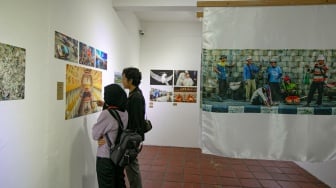 Pengunjung melihat foto yang dipamerkan pada pameran foto Rekam Jakarta 2025 di Cemara 6 Galeri, Jakarta, Sabtu (23/8/2025). [Suara.com/Alfian Winanto]