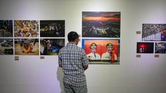 Pengunjung melihat foto yang dipamerkan pada pameran foto Rekam Jakarta 2025 di Cemara 6 Galeri, Jakarta, Sabtu (23/8/2025). [Suara.com/Alfian Winanto]