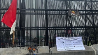 Meski Terhalang Beton Berlumur Oli, Massa Tetap Bisa Kibarkan Bendera One Piece di Gerbang DPR