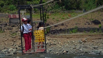Dua siswa sekolah dasar menyeberangi Sungai Tompobulu menggunakan gondola ke Dusun Makmur, Desa Bonto Manurung, Kabupaten Maros, Sulawesi Selatan, Selasa (26/8/2025).  [ANTARA FOTO/Hasrul Said/nz]