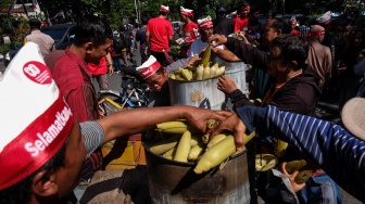 Anggota Peternak Ayam Rakyat Solo Raya membagikan jagung rebus saat aksi damai menyikapi harga jagung pakan ternak yang mahal di kawasan Gladak, Solo, Jawa Tengah, Selasa (26/8/2025). [ANTARAFOTO/Maulana Surya/YU]