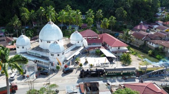 Foto udara lokomotif E1060 Mak Itam melaju dengan membawa wisatawan di Sawahlunto, Sumatera Barat, Selasa (26/8/2025). [ANTARA FOTO/Iggoy el Fitra/nym]