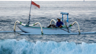 Seorang nelayan menggunakan perahu tradisional yang dilengkapi mesin propulsi listrik saat melaut di Pantai Segara Kusamba, Klungkung, Bali, Rabu (27/8/2025). [ANTARA FOTO/Nyoman Hendra Wibowo/bar]