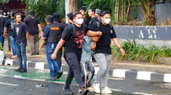 Personel polisi mengamankan pengunjuk rasa saat menggelar aksi di depan Gedung DPR RI, Jakarta, Kamis (28/8/2025). [Suara.com/Alfian Winanto]