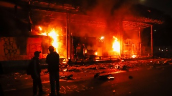 Pengunjuk rasa melihat Gerbang Tol Pejompongan yang dibakar saat aksi di Jakarta, Jumat (29/8/2025). [Suara.com/Alfian Winanto]