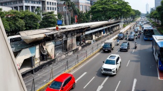 Petugas memperbaiki Halte Transjakarta Senayan pasca terbakar di Jakarta, Senin (1/9/2025). [Suara.com/Alfian Winanto]