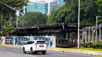 Kendaraan melintas di depan Halte Transjakarta Semanggi yang terbakar, Jakarta, Senin (1/9/2025). [Suara.com/Alfian Winanto]