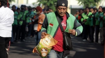 Pengemudi ojek online menerima bantuan beras seusai doa bersama di parkir timur GOR Delta Sidoarjo, Jawa Timur, Jumat (5/9/2025). [ANTARA FOTO/Umarul Faruq/YU]