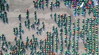 Foto udara ratusan pengemudi ojek online mengikuti doa bersama di parkir timur GOR Delta Sidoarjo, Jawa Timur, Jumat (5/9/2025). [ANTARA FOTO/Umarul Faruq/YU]