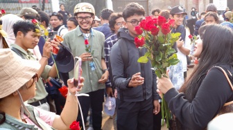 Influencer Gusti Ayu Dewanti membagikan bunga saat mengikuti aksi piknik di depan Gedung DPR RI, Jakarta, Jumat (5/9/2025). [Suara.com/Alfian Winanto]