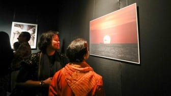 Sejumlah pengunjung mengamati karya foto dalam pameran 80 Tahun Keberagaman Republik Indonesia: Potret Bangsa dalam Lensa di Museum Nasional, Jakarta, Sabtu (6/9/2025). [Suara.com/Alfian Winanto]