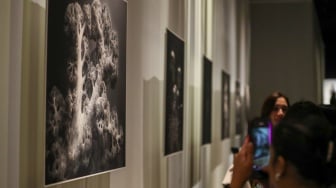Sejumlah pengunjung mengamati karya foto dalam pameran 80 Tahun Keberagaman Republik Indonesia: Potret Bangsa dalam Lensa di Museum Nasional, Jakarta, Sabtu (6/9/2025). [Suara.com/Alfian Winanto]