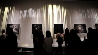 Sejumlah pengunjung mengamati karya foto dalam pameran 80 Tahun Keberagaman Republik Indonesia: Potret Bangsa dalam Lensa di Museum Nasional, Jakarta, Sabtu (6/9/2025). [Suara.com/Alfian Winanto]