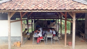 Siswa kelas dua SDN Tegal Benteng belajar di halaman rumah warga di Desa Babakan Raden, Cariu, Kabupaten Bogor, Jawa Barat, Senin (8/9/2025). [ANTARA FOTO/Yulius Satria Wijaya/rwa]