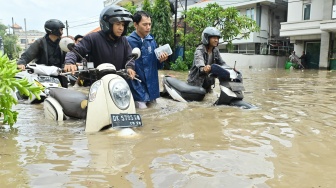 Warga mendorong sepeda motor melewati banjir yang menggenangi kawasan Kuta, Badung, Bali, Rabu (10/9/2025). [ANTARA FOTO/Fikri Yusuf/nym]