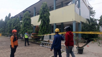 Petugas memasang garis polisi di depan bangunan SMKN 1 Cileungsi yang atapnya ambruk di Kabupaten Bogor, Jawa Barat, Rabu (10/9/2025).  [ANTARA FOTO/Yulius Satria Wijaya/nym]