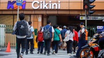 Pejalan kaki menyeberang pada pelican crossing di depan Stasiun Cikini, Jakarta, Senin (15/9/2025). [Suara.com/Alfian Winanto]