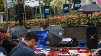 Peserta aksi yang tergabung dalam Koalisi Masyarakat Sipil Untuk Reformasi Sektor Keamanan mengangkat poster saat mengikuti aksi di depan Gedung Mahkamah Konstitusi (MK), Jakarta, Rabu (17/9/2025). [Suara.com/Alfian Winanto]