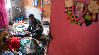 Prajurit TNI AD anggota Kodim 0906/Kutai Kartanegara, Peltu Suhendro memeriksa kesehatan warga saat melakukan pelayanan klinik terapung di kawasan Loa Ipuh, Tenggarong, Kutai Kartanegara, Kalimantan Timur, Jumat (19/9/2025). [ANTARA FOTO/M Risyal Hidayat/tom]