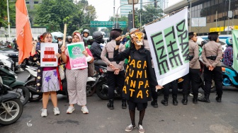 Aktivis dari berbagai organisasi melakukan aksi Draw the Line dengan cara long march dari terowongan Kendal menuju Monas, Jakarta, Jumat (19/9/2025). [Suara.com/Alfian Winanto]