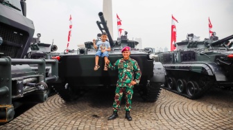 Pengunjung berswafoto dengan kendaraan tempur TNI saat pameran alat utama sistem senjata (alutsista) TNI Fair di Monas, Jakarta, Minggu (21/9/2025). [Suara.com/Alfian Winanto]
