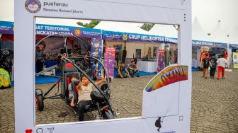 Pengunjung mencoba purwarupa kendaraan tempur TNI saat pameran alat utama sistem senjata (alutsista) TNI Fair di Monas, Jakarta, Minggu (21/9/2025). [Suara.com/Alfian Winanto]
