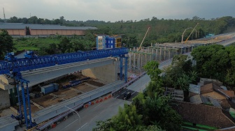 Foto udara kendaraan melintas di dekat pembangunan akses Jalan Tol Yogyakarta-Bawen Seksi 6, Bawen, Kabupaten Semarang, Jawa Tengah, Rabu (24/9/2025). [ANTARA FOTO/Makna Zaezar/nz]