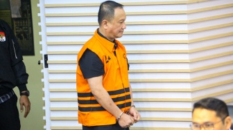 Dirut PT Wahana Adyawarna, Menas Erwin Djohansyah mengenakan rompi tahanan usai menjalani pemeriksaan di Gedung Merah Putih KPK, Jakarta, Kamis (25/9/2025). [Suara.com/Alfian Winanto]