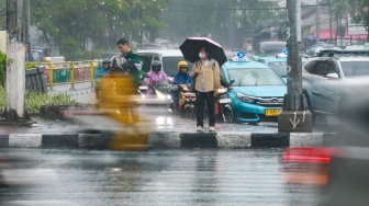 Pejalan kaki menggunakan payung saat hujan di Kawasan Slipi, Jakarta, Senin (29/9/2025). [Suara.com/Alfian Winanto]