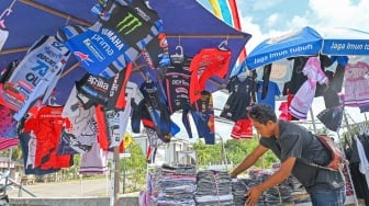 Pedagang menata kaos serta pernak-pernik bertema MotoGP di depan Sirkuit Mandalika, KEK Mandalika, Kuta, Praya, Lombok Tengah, NTB, Senin (29/9/2025). [ANTARA FOTO/Ahmad Subaidi/bar]
