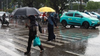 Pejalan kaki menggunakan payung saat hujan di Kawasan Slipi, Jakarta, Senin (29/9/2025). [Suara.com/Alfian Winanto]