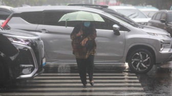 Pejalan kaki menggunakan payung saat hujan di Kawasan Slipi, Jakarta, Senin (29/9/2025). [Suara.com/Alfian Winanto]