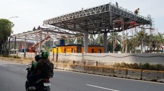 Pekerja menyelesaikan proyek perbaikan Gerbang Tol Pejompongan, Jakarta, Selasa (30/9/2025). [Suara.com/Alfian Winanto]