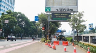 Pekerja menyelesaikan proyek perbaikan Gerbang Tol Pejompongan, Jakarta, Selasa (30/9/2025). [Suara.com/Alfian Winanto]