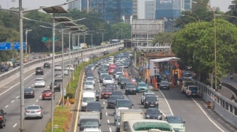 Pekerja menyelesaikan proyek perbaikan Gerbang Tol Pejompongan, Jakarta, Selasa (30/9/2025). [Suara.com/Alfian Winanto]