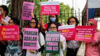 Massa yang tergabung dalam Suara Ibu Peduli Makan Bergizi Gratis (MBG) melakukan aksi di trotoar sekitar IRTI Monas, Jakarta, Rabu (1/10/2025). [Suara.com/Alfian Winanto]