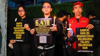 Massa yang tergabung dalam Koalisi Masyarakat Sipil menggelar aksi peringatan satu bulan korban tragedi aksi Agustus di kawasan Bendungan Hilir, Jakarta, Selasa (30/9/2025) malam. [Suara.com/Alfian Winanto]
