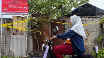Warga menaiki sepeda listrik saat melintas di dekat plang pengawasan kerawanan bahaya radiasi yang terpasang di lokasi ditemukannya cemaran Cesium-137 (Cs-137) di Kawasan Industri Modern Cikande, Kabupaten Serang, Banten, Kamis (2/10/2025). [ANTARA FOTO/Angga Budhiyanto/nym]