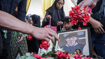 Sejumlah rekan dan keluarga menaburkan bunga saat menghadiri pemakaman atlet nasional gimnastik Indonesia Naufal Takdir Al Bari di TPU Tlogopojok, Gresik, Jawa Timur, Jumat (3/10/2025). [ANTARA FOTO/Rizal Hanafi/rwa]