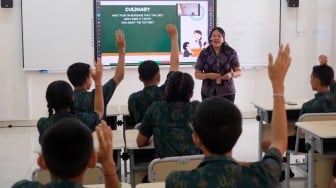 Seorang guru memberikan penjelasan kepada siswa yang mengikuti pelajaran bahasa inggris dengan metode pembelajaran smart classroom atau ruang kelas pintar di SMP Negeri 15 Denpasar, Bali, Jumat (3/10/2025). [ANTARA FOTO/Nyoman Hendra Wibowo/YU]