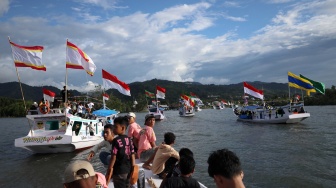 Sejumlah warga berada di atas kapal nelayan berhias bendera berkeliling saat mengikuti pesta nelayan di kawasan Pantai Kasiwa, Mamuju, Sulawesi Barat, minggu (5/10/2025). [ANTARA FOTO/Akbar Tado/foc]