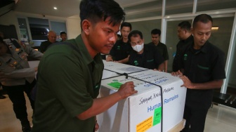 Petugas kargo jenazah menurunkan peti jenazah Alm Yurike Marianne Sanger setibanya dari Kota New York , Amerika Serikat di Terminal kargo Bandara Soekarno Hatta, Tangerang, Banten, Minggu (5/10/2025). [ANTARA FOTO/Muhammad Iqbal/foc]